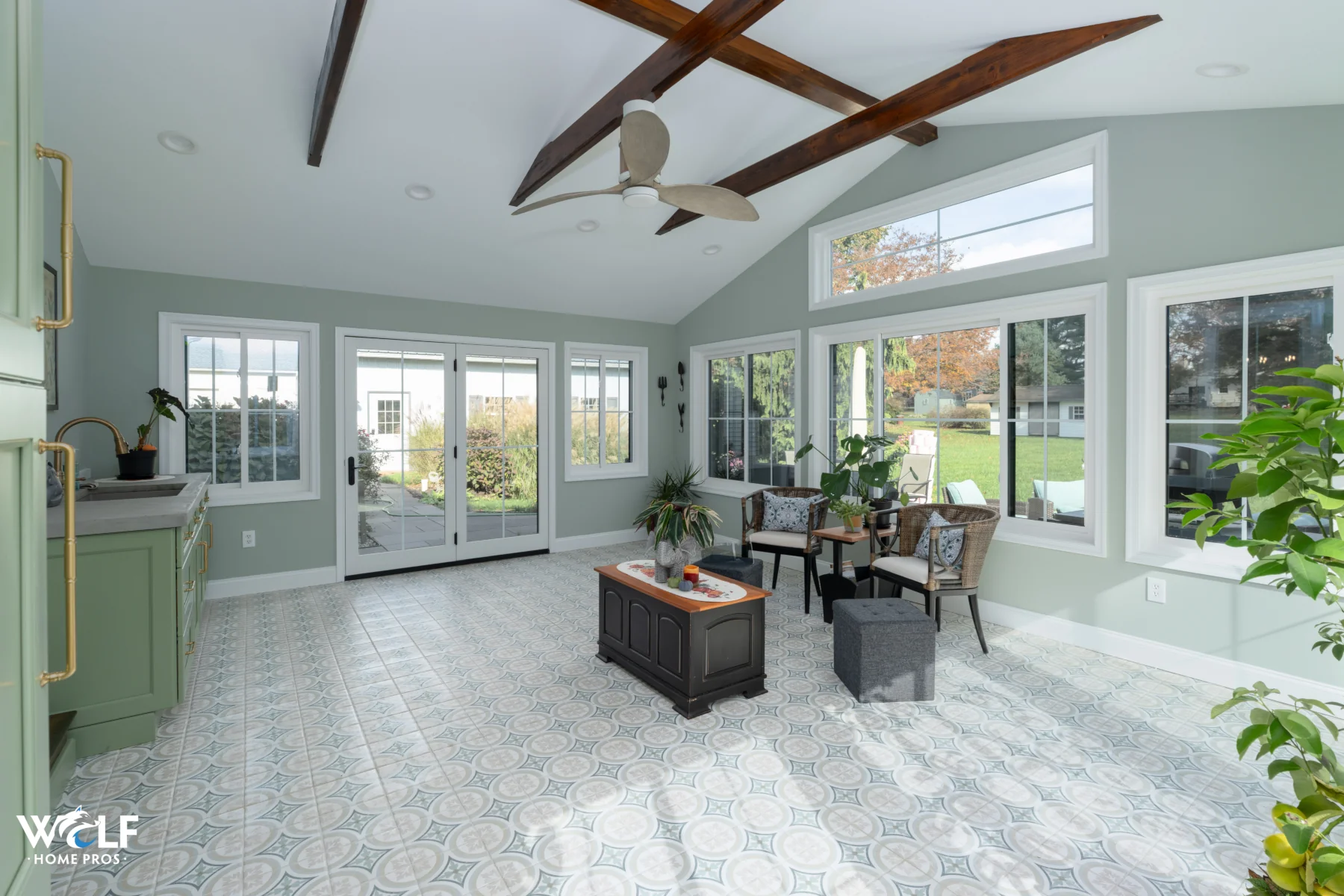 Sunroom remodel in Coatesville, PA with new flooring, custom cabinetry, window replacements, concrete countertop, and back door replacement by Wolf Home Pros