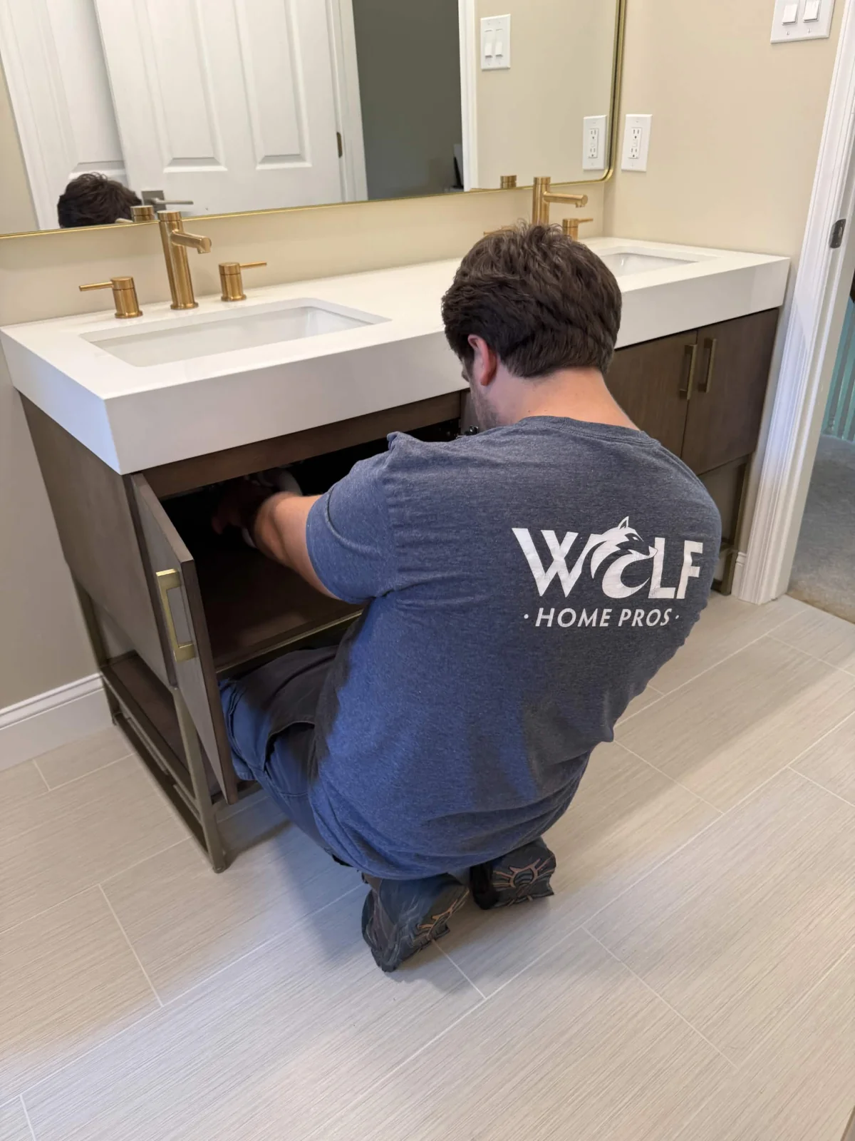 Wolf Home Pros handyman installing a bathroom vanity during a remodel in Malvern, PA.