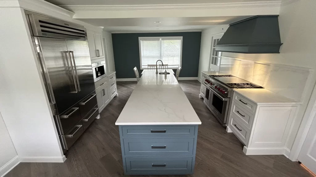 Kitchen remodel in Berwyn, PA with custom cabinets, a large island, new appliances, hardwood floors, and a custom range hood by Wolf Home Pros