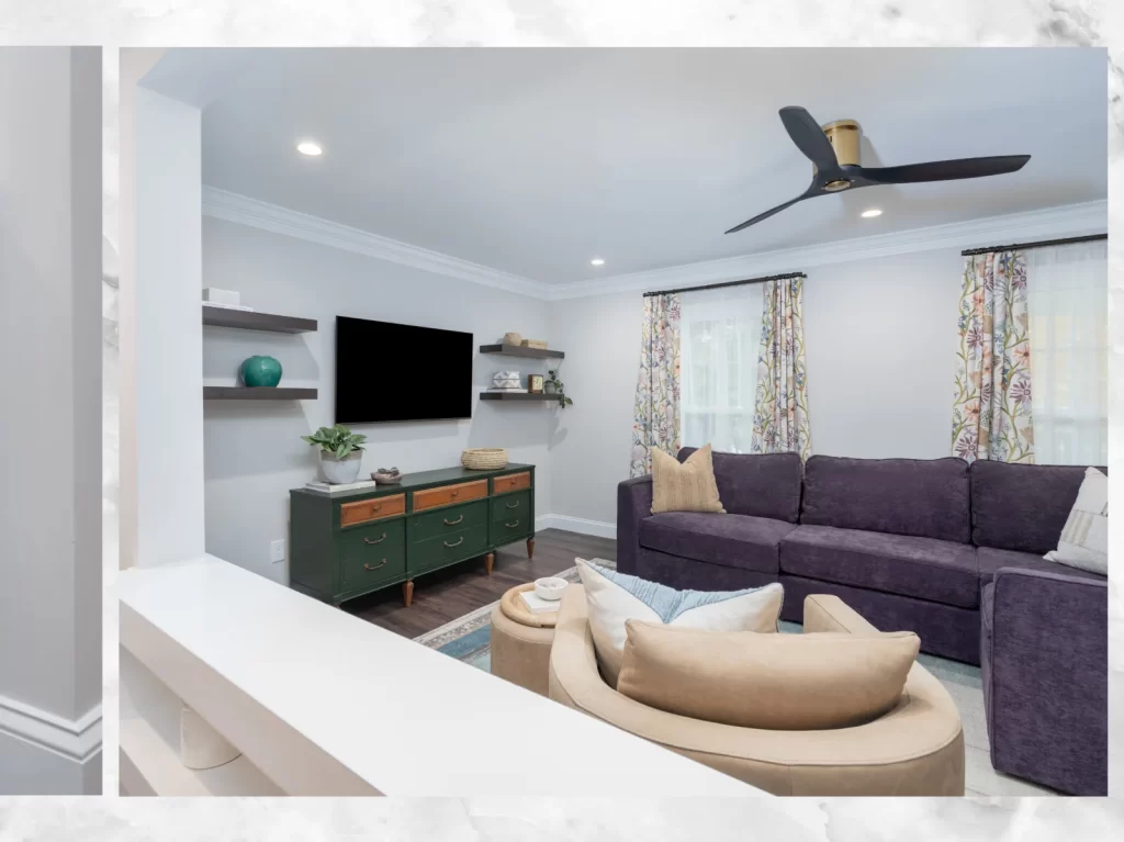 Finished living room in a Coatesville, PA first-floor remodel with floating shelves, updated flooring, crown molding, ceiling fan and open connection to the adjoining rooms.