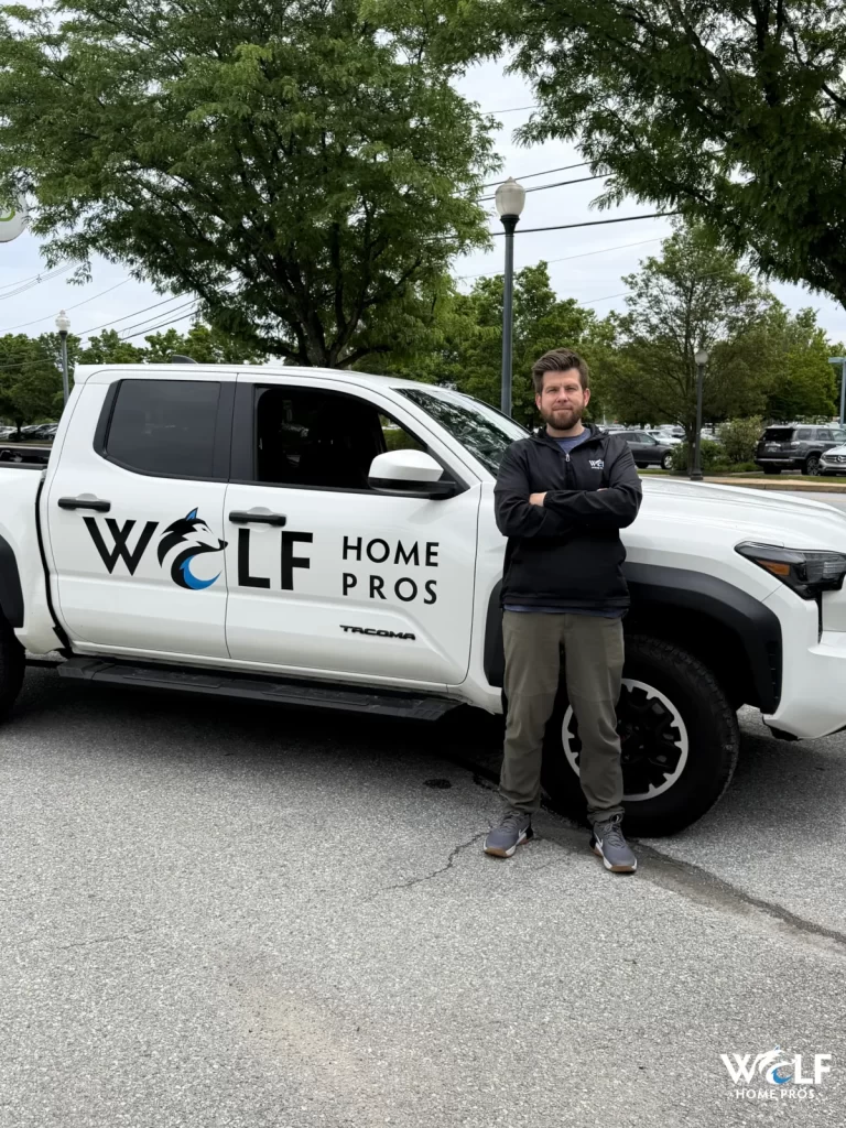Dan Wolf standing beside a Wolf Home Pros work truck.
