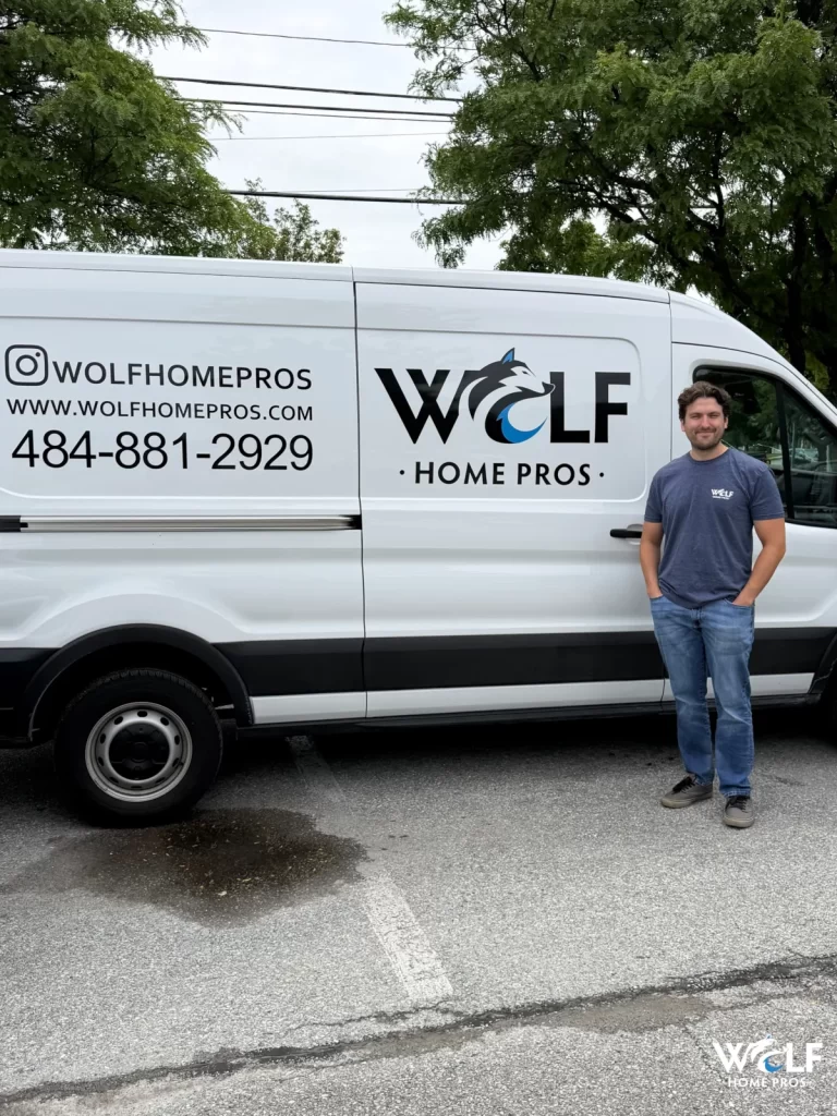 Phil Wolf standing beside a Wolf Home Pros service van.