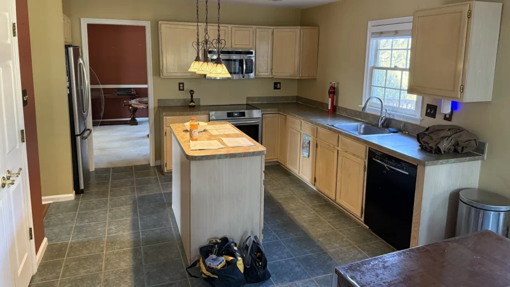 Downingtown, PA kitchen before remodeling with older cabinetry, countertops, tile flooring, and center island.