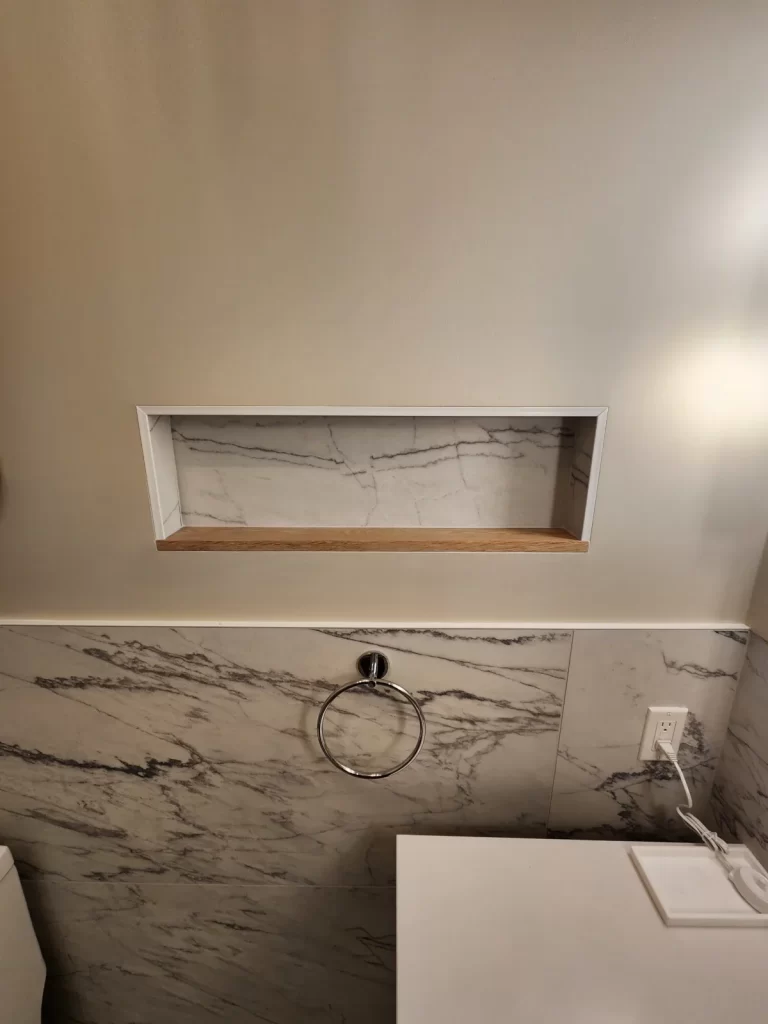 Recessed wall niche in a Villanova, PA bathroom remodel with matching tile and a wood shelf detail.