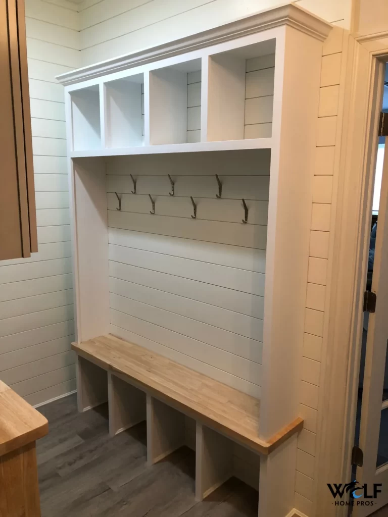 Custom mudroom built-in in Wayne, PA with a bench, coat hooks, open shelving, and shoe storage by Wolf Home Pros.