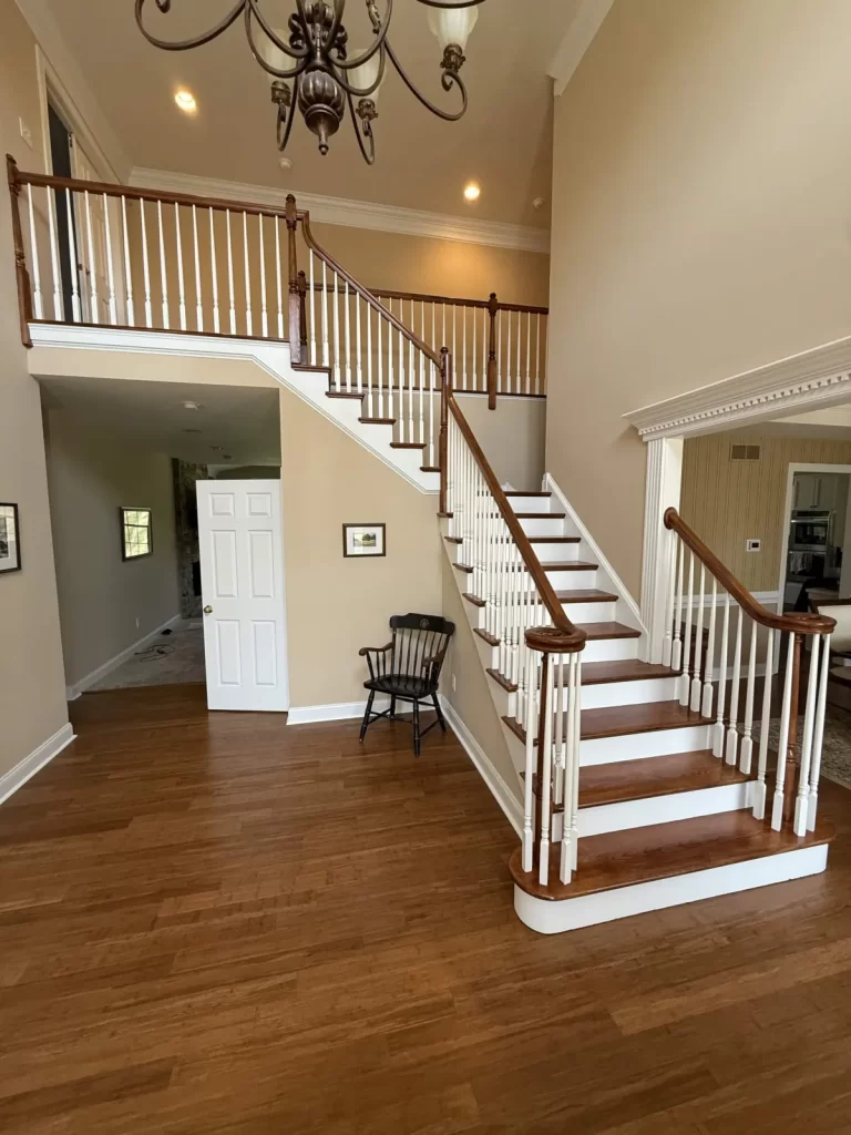 Refinished staircase in Wayne, PA with wood treads and handrails, white risers and balusters, and an upper-level railing.