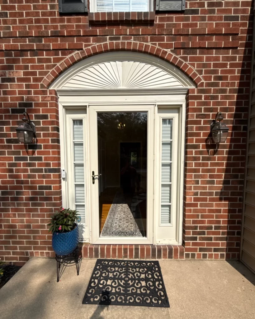 Front door replacement in West Chester, PA with glass entry door, sidelights, arched transom, and brick exterior.