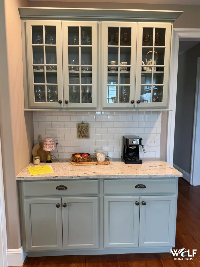 Finished kitchen cabinetry and white tile backsplash in West Chester, PA with glass-front cabinets and stone countertop.