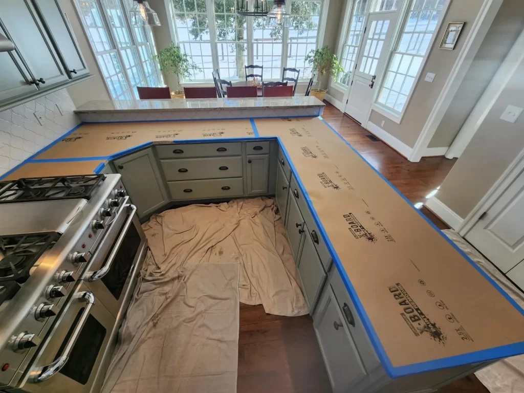 West Chester kitchen during backsplash preparation with countertops protected by X-Board and taped edges before work begins.